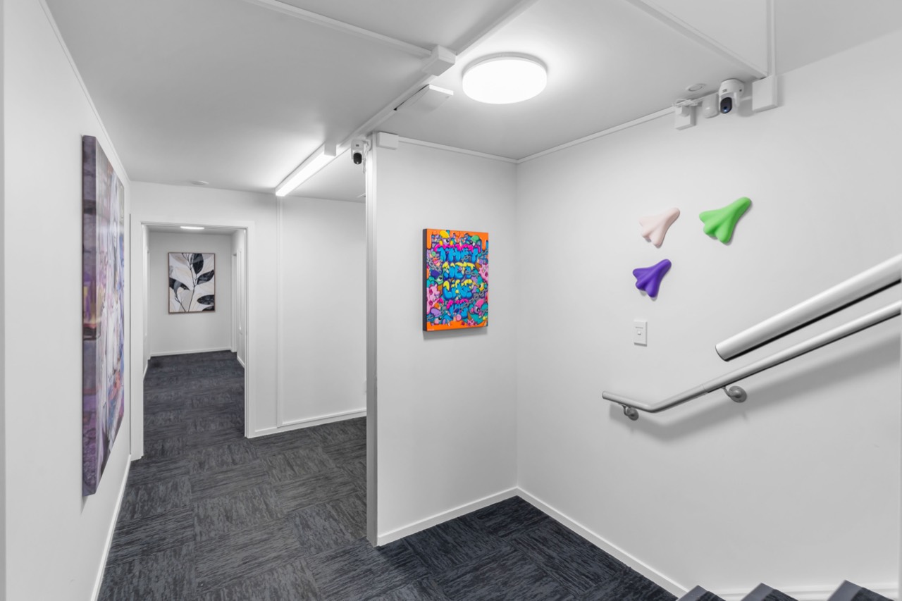 The stairs to the studios, with artwork on the walls